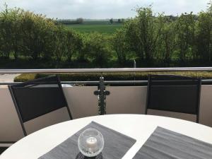 a table with a candle on a balcony with a view at Fehmarn 17-1 in Fehmarn