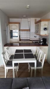 a kitchen with a white table and chairs in it at Strandhotel Wohnung 31 in Dahme