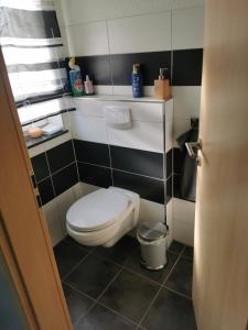 a bathroom with a white toilet and black and white tiles at Zimmer zum übernachten wg in Münsingen