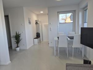 a dining room with a table and white chairs at Wohnung in Dahme