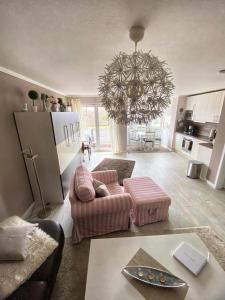 a living room with a couch and a chandelier at Seeschloss Wohnung 22 in Dahme +20 photos