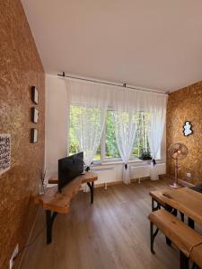 a living room with a tv and a table and windows at visitDINAMO in Kandava