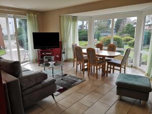 a living room with a table and chairs and a tv at Nordstern 3 in Dahme