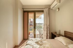 a bedroom with a bed and a large window at 3BD Apartment in the Center - Self check in in Patra