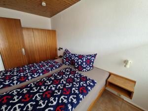 a bedroom with a bed with a blue and red blanket at Feriengarten Dahme W 8 in Dahme