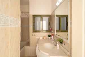 a bathroom with a sink and a large mirror at 3BD Apartment in the Center - Self check in in Patra +17 photos