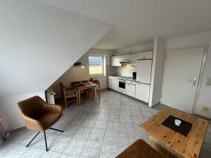 a living room with a table and a kitchen at Fehmarn 17-6 in Fehmarn