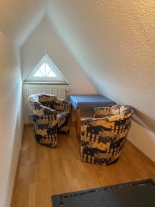 two chairs and a table in a room with stairs at Fehmarn 17-6 in Fehmarn +4 photos
