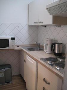 a small kitchen with a sink and a microwave at Feriengarten Dahme W 13 in Dahme