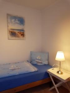 a bedroom with a blue bed and a table with a lamp at Feriengarten Dahme W 13 in Dahme
