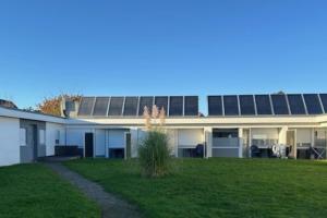 a large building with a green lawn in front of it at Feriengarten Dahme W 13 in Dahme