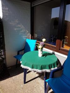 a table and two chairs with a vase of flowers at Feriengarten Dahme W 13 in Dahme