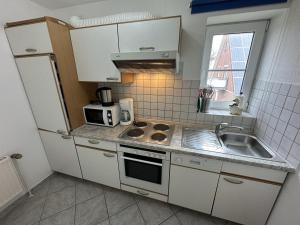 a small kitchen with a sink and a microwave at Fehmarn 17-5 in Fehmarn