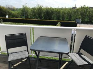 a table and two chairs on a balcony at Fehmarn 17-5 in Fehmarn +3 photos