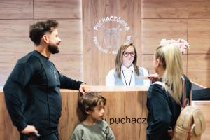 a group of people standing around a reception desk at Willa Puchaczówka in Sienna