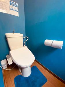 ein Badezimmer mit weißer Toilette und blauer Wand in der Unterkunft Guest House 楽風 in Anan + 17 Fotos