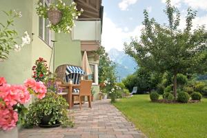 a patio with a table and chairs and flowers at Apart Heim in Ramsau im Zillertal