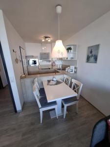 a kitchen and dining room with a table and chairs at Strandhotel Wohnung 30 in Dahme