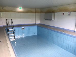 a swimming pool with a ladder in the middle of it at Strandhotel Wohnung 30 in Dahme
