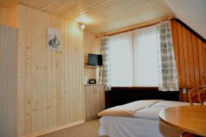 a bedroom with a bed and a window and a table at Dom Goscinny Jawor Czarnypotok in Krynica Zdrój