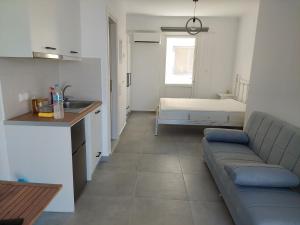 a living room with a couch and a bed at Almiriki- Ground Floor Seafront Studio in Elafonisos