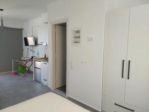 a room with white cabinets and a kitchen with a counter at Almiriki- Ground Floor Seafront Studio in Elafonisos