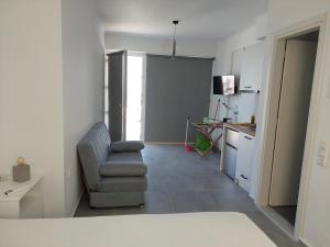 a living room with a chair and a kitchen at Almiriki- Ground Floor Seafront Studio in Elafonisos +5 photos