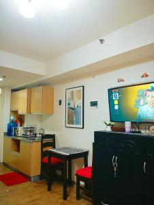 a room with a kitchen with a tv on the wall at Amani Airport Haven - 726 in Pusok