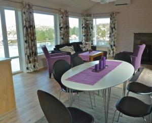 a living room with a table and purple chairs at Hagland Lille Haugesund 8x Ferienhaus incl Motorboot in Hagland
