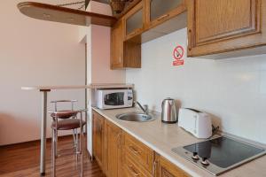 a small kitchen with a sink and a microwave at Затишна квартира біля Майдану Незалежності in Kyiv