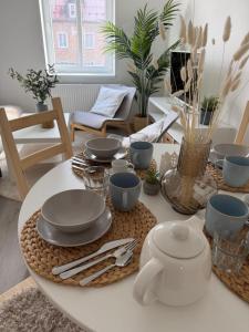 a table with plates and utensils on top of it at Apartmány Loučky Litvínov in Litvínov