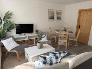 a living room with a couch and a tv and a table at Apartmány Loučky Litvínov in Litvínov