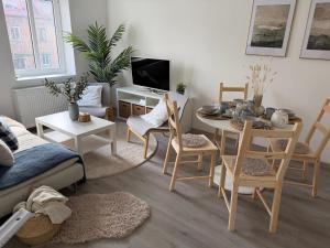 a living room with a table and chairs and a tv at Apartmány Loučky Litvínov in Litvínov