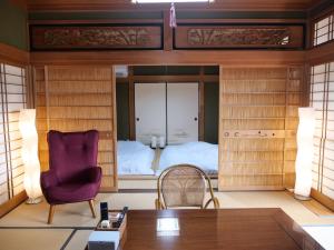 a room with a bed and a chair and a table at Inn Azur in Yamatotakada