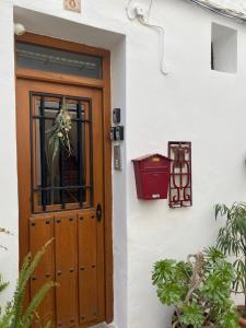 a wooden door on a white building with plants at Apartamentos turísticos "El Refugio" in Algar de Palancia
