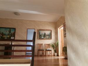 a living room with two chairs and a staircase at Casa Maria in Negreşti-Oaş