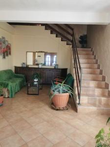 a living room with a staircase and a green couch at Casa Maria in Negreşti-Oaş