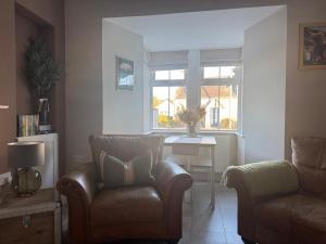 a living room with a couch and a chair and a table at Altonhill Cottage - room only in Nairn