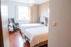 a bedroom with two beds and a chair and a window at Refúgio das Velhas in Vila Nova de Cerveira +75 photos