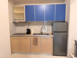 a kitchen with blue cabinets and a stainless steel refrigerator at Aggelos Room 1 in Volos