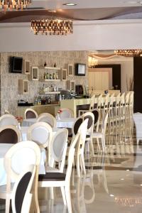 マルマリにあるEvia Hotel & Suitesの白い椅子とバーのあるレストラン
