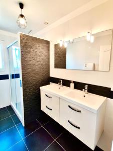 a bathroom with a white sink and a mirror at L'Écrin d'Ussat in Ussat +34 photos