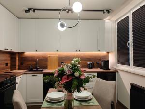 a kitchen with a table with a vase of flowers on it at Studio 27 in Zabrze +11 photos