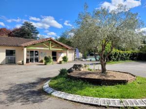 a tree in a circle in front of a building at Studiotel premium 2 personnes in Pamiers
