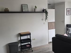 a living room with a shelf and a chair at Hooisma's Erf in Kampen