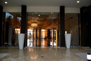 マルマリにあるEvia Hotel & Suitesの白い花瓶が3本敷かれたロビー