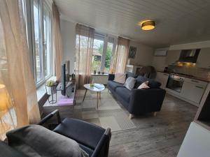 a living room with a couch and chairs and a table at Hooisma's Erf in Kampen