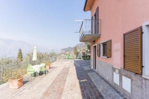 a walkway next to a pink building with a balcony at Appartamenti Ceccherini Debora Alice in Malcesine