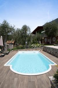 a large swimming pool on a wooden deck at Appartamenti Ceccherini Debora Alice in Malcesine +20 photos