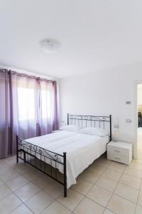 a bedroom with a large bed with white sheets at Appartamenti Ceccherini Debora Alice in Malcesine
